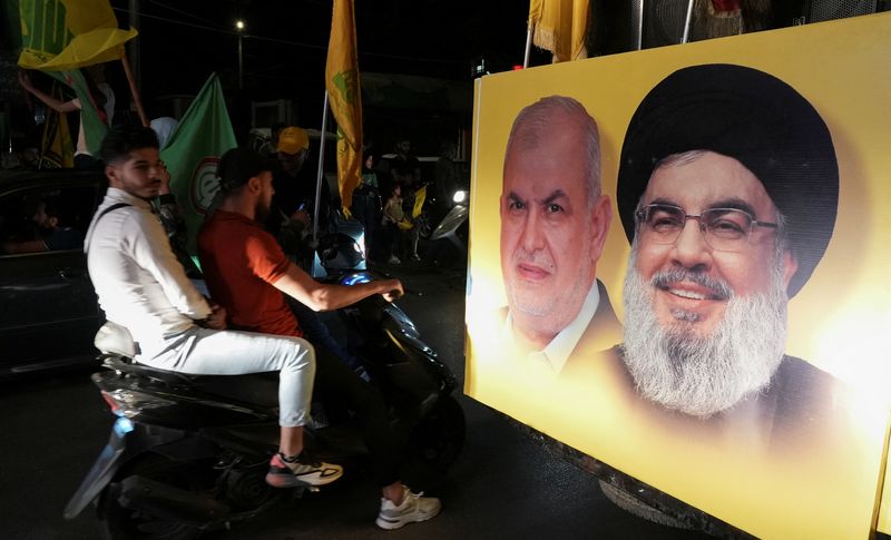 &copy; Reuters. Supporters carry Hezbollah and Amal Movement flags as they ride in a convoy past a poster depicting Hezbollah leader Sayyed Hassan Nasrallah and Head of Hezbollah's parliamentary bloc Mohamed Raad, as votes are being counted in Lebanon's parliamentary ele