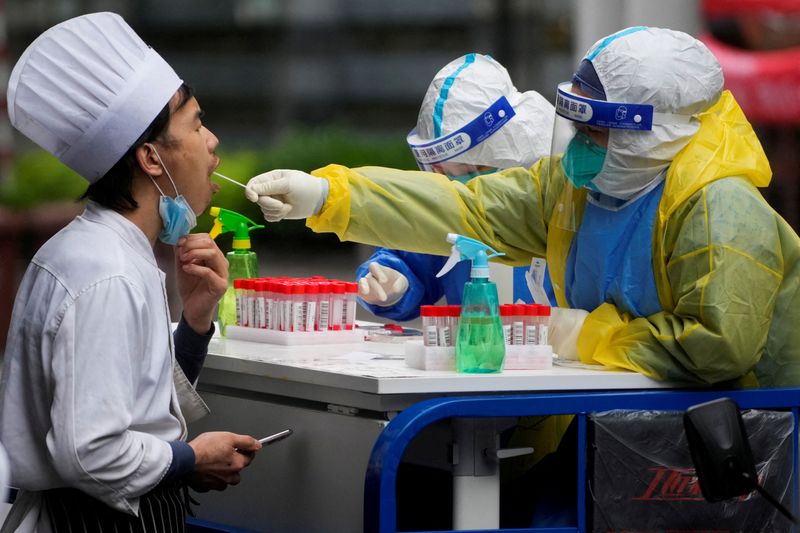 &copy; Reuters. 　５月１６日、上海市当局者は、６月１日から市内で通常の生活をより広範に再開することを目指すと述べた。写真は新型コロナウイルス検査の様子。上海で１３日撮影（２０２２年　ロイ