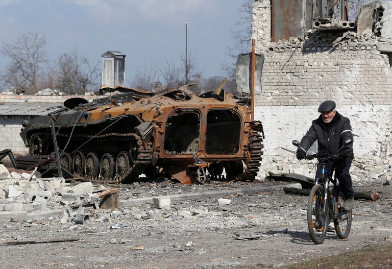&copy; Reuters. FOTO DE ARCHIVO. Un residente local pasa en bicicleta junto a un vehículo blindado carbonizado durante el conflicto entre Ucrania y Rusia en la ciudad de Volnovaja, controlada por los separatistas, en la región de Donetsk, Ucrania. 15 de marzo de 2022. 