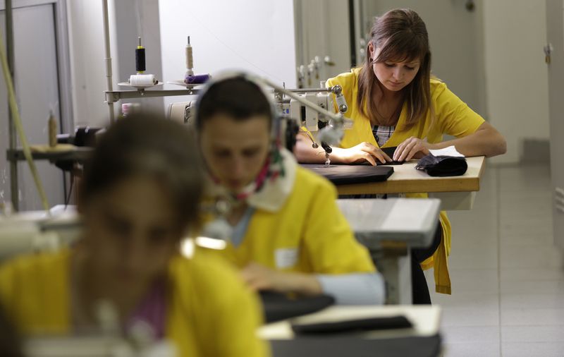 &copy; Reuters. FILE PHOTO: Bulgarian Nevse Molalieva (R) works at a sewing machine during her training course in a sewing factory in Gotse Delchev, some 200km (118 miles) south of Sofia May 9, 2013. REUTERS/Stoyan Nenov 