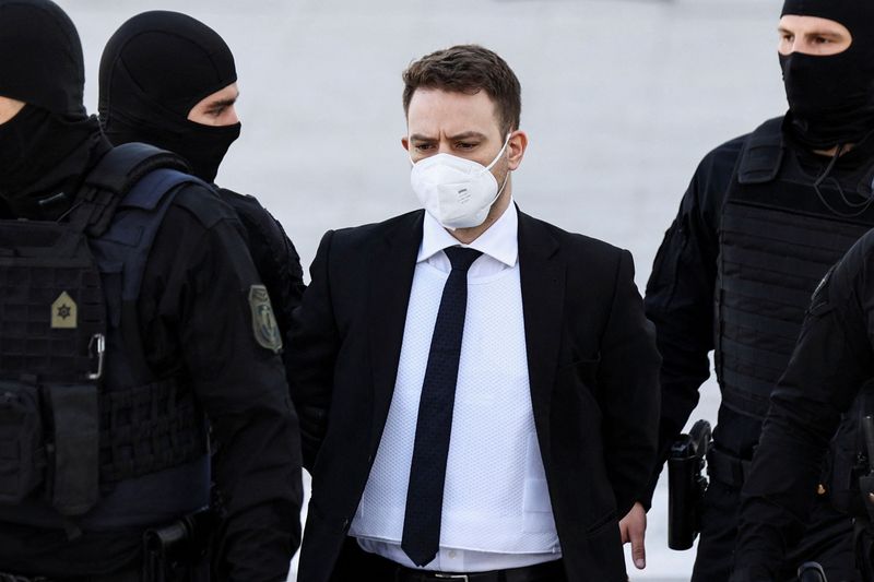 &copy; Reuters. FILE PHOTO: A 33-year-old man, who is charged with the intentional homicide of his 20-year-old wife, is escorted to the court for the beginning of his trial in Athens, Greece, April 8, 2022. REUTERS/Louiza Vradi/File Photo