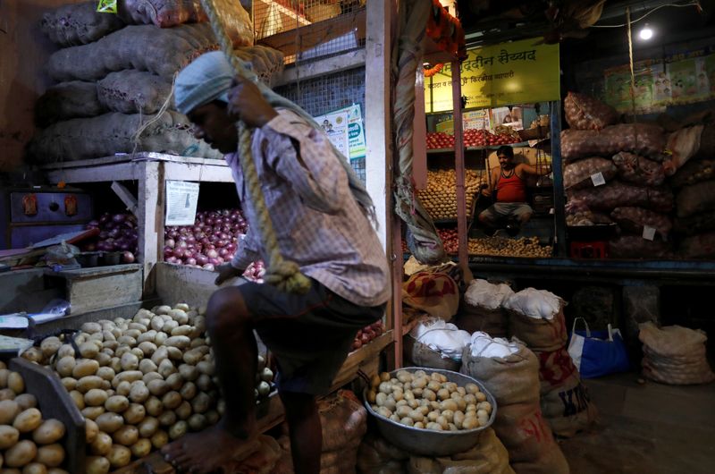 &copy; Reuters. FILE PHOTO: A vendor climbs to his stall as another waits for customers at a wholesale vegetable market in Mumbai, India, March 14, 2018. REUTERS/Danish Siddiqui