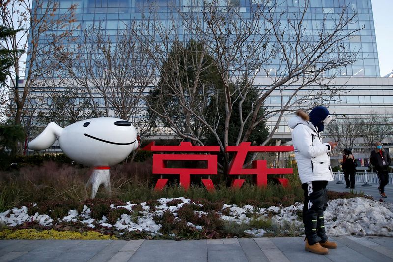 &copy; Reuters. FILE PHOTO: A man stands outside JD.Com’s headquarters, amid the Singles' Day shopping festival, during an organised tour in Beijing, China, November 9, 2021. REUTERS/Tingshu Wang/