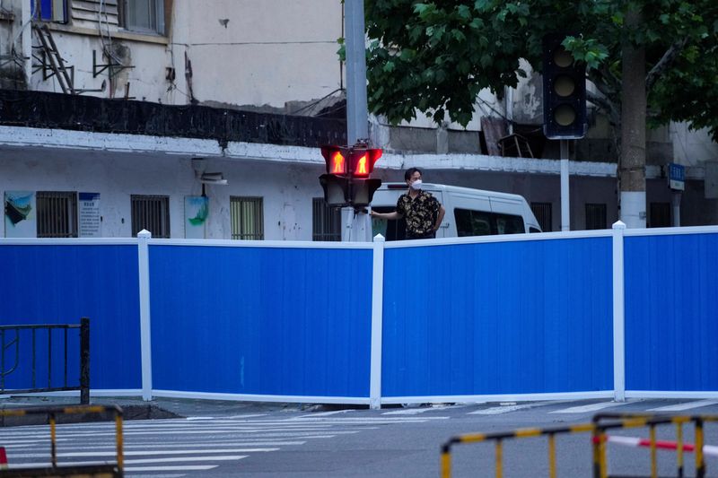 &copy; Reuters. Homem observa sobre barreiras colocadas em rua durante lockdown para conter a disseminação da Covid-19 em Xangai, na China
16/05/2022 REUTERS/Aly Song