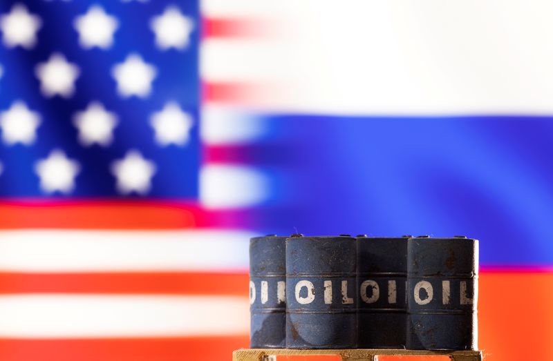 &copy; Reuters. Una miniatura di barili di greggio davanti bandiere degli Stati Uniti e della Russia. REUTERS/Dado Ruvic/