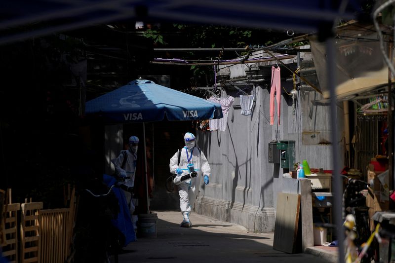 © Reuters. Workers in protective suits disinfect a closed residential area during lockdown, amid the coronavirus disease (COVID-19) outbreak, in Shanghai, China, May 18, 2022. REUTERS/Aly Song sizes=