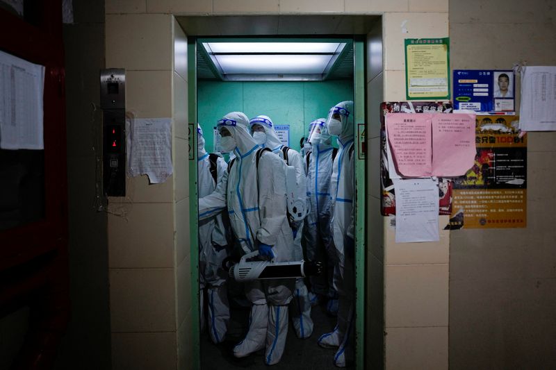 &copy; Reuters. Workers in protective suits take an elevator as they disinfect a residential area during lockdown, amid the coronavirus disease (COVID-19) pandemic, in Shanghai, China, May 18, 2022. REUTERS/Aly Song