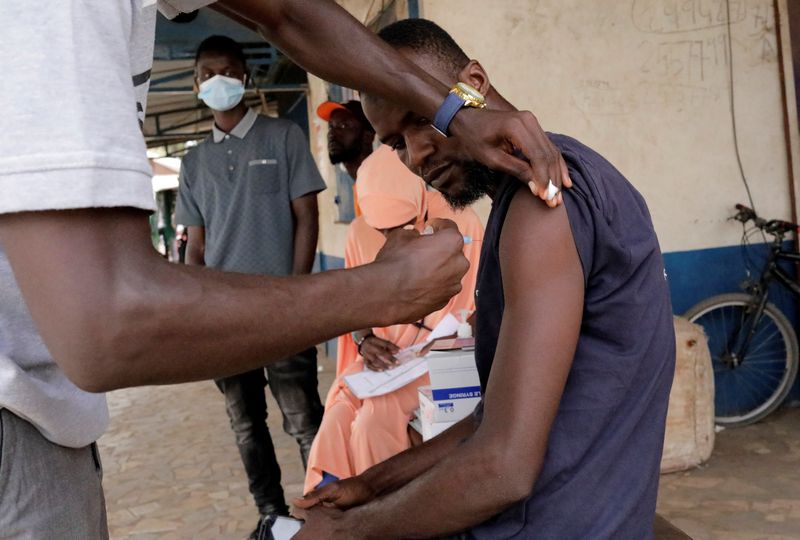 &copy; Reuters. Sulayman Jalloh, an heath worker vaccinates a driver from the Bundung garage during a mobile vaccination campaign against COVID-19 in Banjul, Gambia May 11, 2022. REUTERS/ Ngouda Dione 