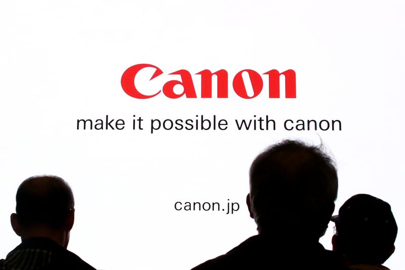 &copy; Reuters. People are silhouetted against a display of the Canon brand logo at the CP+ camera and photo trade fair in Yokohama, Japan, February 25, 2016. REUTERS/Thomas Peter/Fies