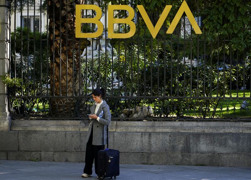 &copy; Reuters. FOTO DE ARCHIVO: Una mujer mira su teléfono móvil frente al edificio del banco español BBVA en Madrid, España, 15 de noviembre de 2021. REUTERS/Juan Medina