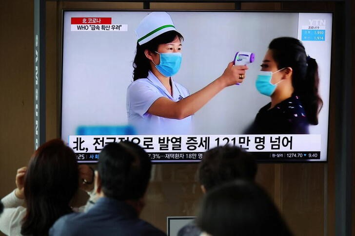 &copy; Reuters. أناس يتابعون تقريرا عن تفشي فيروس كورونا في كوريا الشمالية يذيعه التلفزيون في محطة للقطارات في سول عاصمة كوريا الجنوبية يوم 17 مايو أيار 2022. 