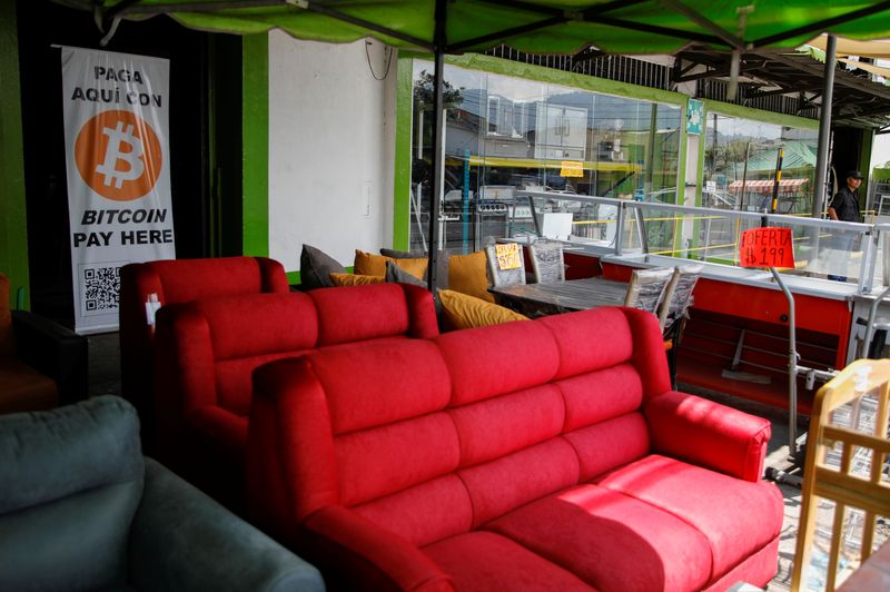 &copy; Reuters. FILE PHOTO - A sign reading “Pay with Bitcoin here” is set in a furniture store in San Salvador, El Salvador March 10, 2022. REUTERS/Jose Cabezas