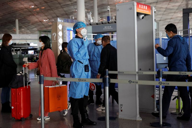 &copy; Reuters. FOTO DE ARCHIVO: Miembros del personal médico comprueban la temperatura de las personas al entrar en el Aeropuerto de la Capital, tras un brote de la enfermedad del coronavirus (COVID-19), en Pekín, China, 5 de noviembre de 2020. REUTERS/Thomas Peter
