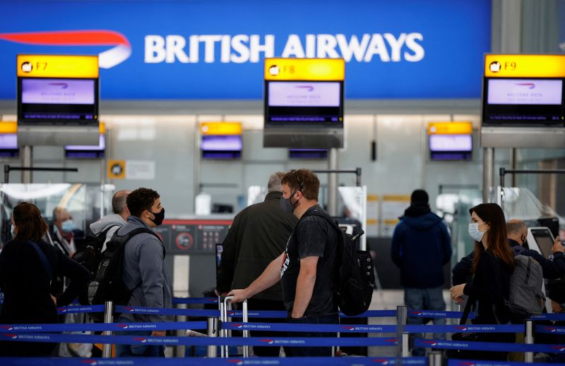&copy; Reuters. FILE PHOTO: Passengers stand in a queue to the British Airways check-in desks in the departures area of Terminal 5 at Heathrow Airport in London, Britain, May 17, 2021. REUTERS/John Sibley