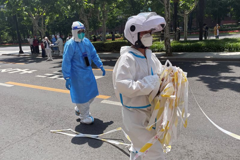 &copy; Reuters. Funcionário em trajes de proteção remove cordão de isolamento de área residencial em Xangai, na China
18/05/2022 REUTERS/Casey Hall