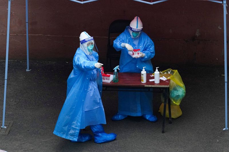 &copy; Reuters. Trabajadores con trajes de protección en un sitio de pruebas de ácido nucleico durante el cierre, durante la pandemia de coronavirus (COVID-19), en Shanghái, China, 26 de abril de 2022. REUTERS/Aly Song
