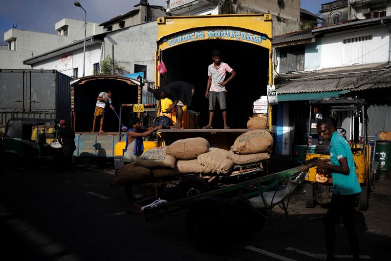 © Reuters. Laborers wait after unloading the sacks of rice at a wholesale market, amid the country's economic crisis in Colombo, Sri Lanka, May 20, 2022. REUTERS/Adnan Abidi