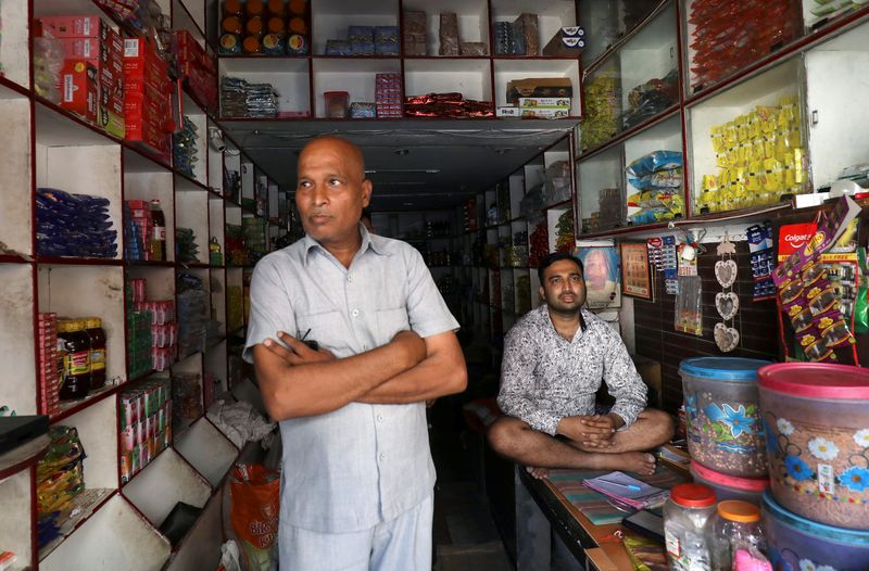 &copy; Reuters. FILE PHOTO: Rahul Jain (R), a shopkeeper selling groceries, looks on as he waits for customers at Kasan village in Manesar, in the northern state of Haryana, India, August 11, 2019. REUTERS/Anushree Fadnavis