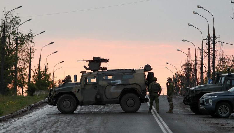 &copy; Reuters. Des membres des troupes pro-russes montaient la garde avant le départ attendu des soldats ukrainiens qui se sont rendus à l'aciérie assiégée d'Azovstal, à Mariupol. Près de 2.000 soldats ukrainiens qui étaient retranchés dans l'aciérie Azovstal 