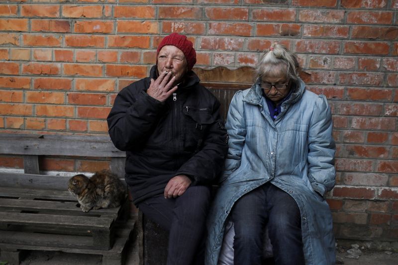 &copy; Reuters. Natalia Parkomento, 60, smokes as she sits next to her roomate Vera Fillipova, 65, outside their home in Slatyne village, amid Russia's attack on Ukraine, in Kharkiv region, Ukraine, May 18, 2022. REUTERS/Ricardo Moraes