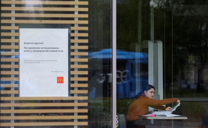 &copy; Reuters. An employee works with documents inside a McDonald's restaurant next to a board informing of the restaurant's temporary closure in Moscow, Russia May 16, 2022. REUTERS/Evgenia Novozhenina