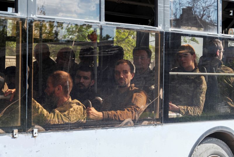 &copy; Reuters. A bus carrying service members of the Ukrainian armed forces, who surrendered at the besieged Azovstal steel mill, drives away under escort of the pro-Russian military in the course of the Ukraine-Russia conflict, in Mariupol, Ukraine May 20, 2022. REUTER