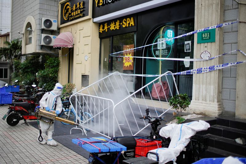 &copy; Reuters. FILE PHOTO: A worker in a protective suit disinfects a street during lockdown, amid the coronavirus disease (COVID-19) outbreak, in Shanghai, China, May 20, 2022. REUTERS/Aly Song