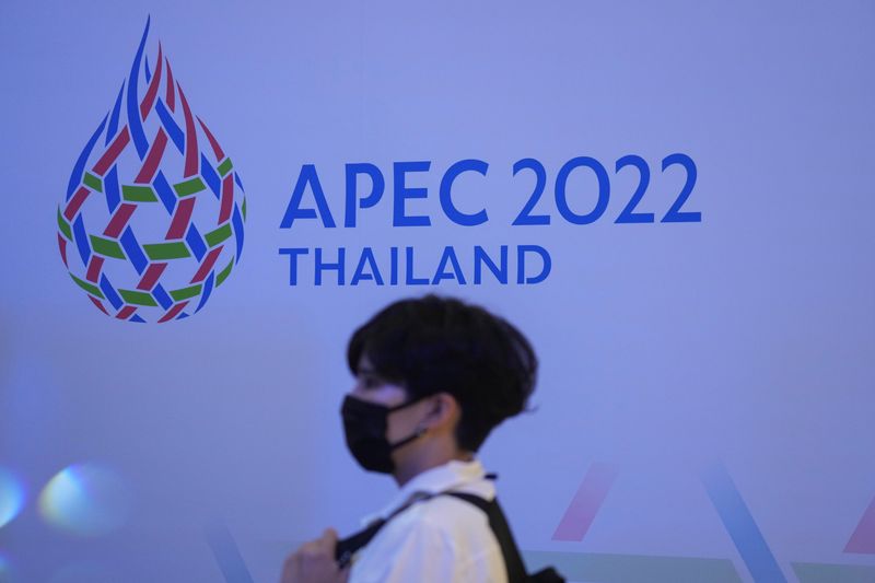 &copy; Reuters. سيدة تمر أمام الشعار الجديد لمنتدى التعاون الاقتصادي لدول آسيا والمحيط الهادي (أبك) في بانكوك يوم 18 نوفمبر تشرين الثاني 2021. تصوير: رويترز.