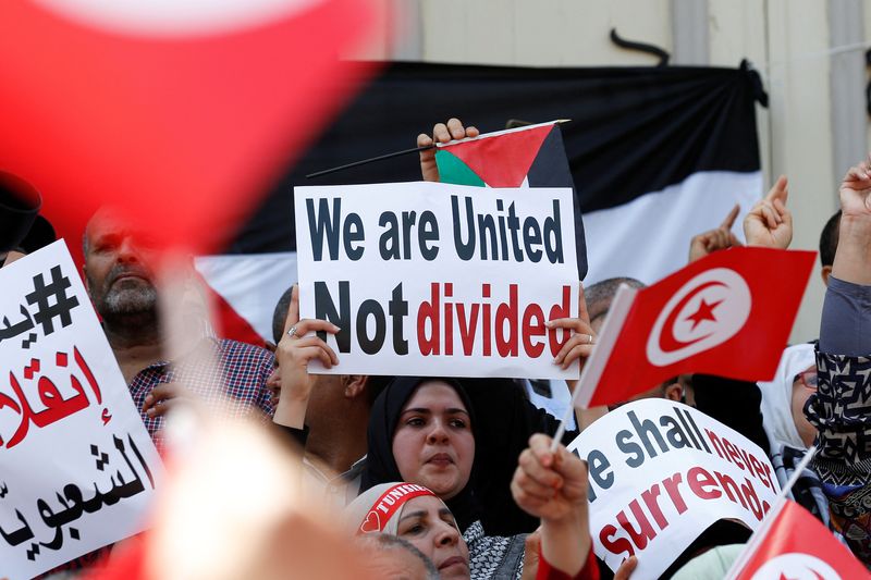 &copy; Reuters. متظاهرون يرفعون الأعلام التونسية واللافتات خلال مظاهرة احتجاجية ضد الرئيس التونسي قيس سعيد في العاصمة تونس يوم 15 من مايو أيار 2022. تصوير: زبي