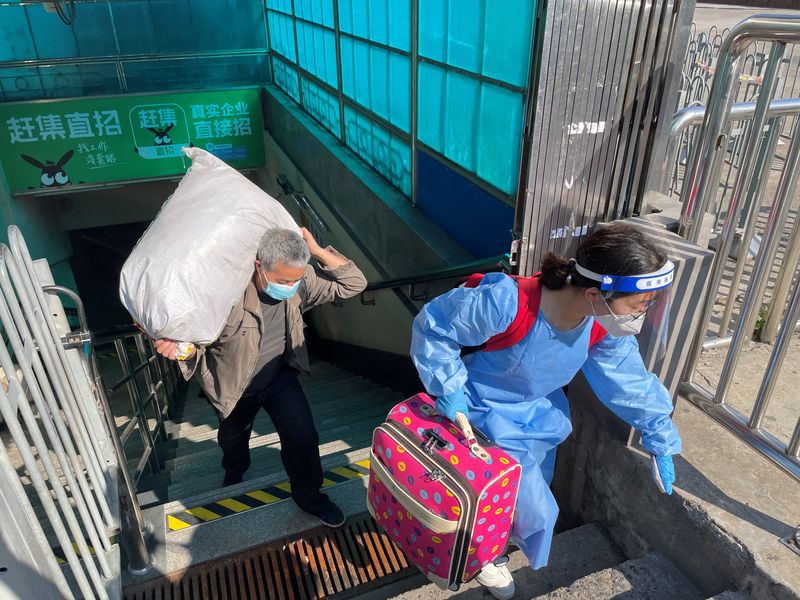 © Reuters. Travellers carrying luggages leave a subway station on the first day of parts of city's subway services resumed, following the coronavirus disease (COVID-19) outbreak in Shanghai, China May 22, 2022. REUTERS/Brenda Goh