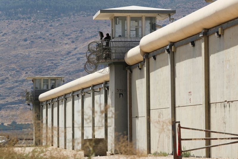 © Reuters. حارس يقف فوق أحد أبراج المراقبة الموزعة بطول سور سجن جلبوع شديد الحراسة في شمال إسرائيل، والذي نجح ستة نشطاء فلسطينيين في الهرب منه عام 2021 قبل إلقاء القبض عليهم. تصوير: عمار عوض - رويترز
