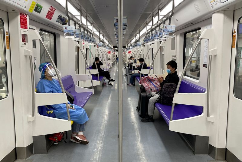&copy; Reuters. راكب يرتدي بدلة واقية في قطار مترو الأنفاق في شنغهاي يوم الأحد. تصوير: بريندا جوه - رويترز