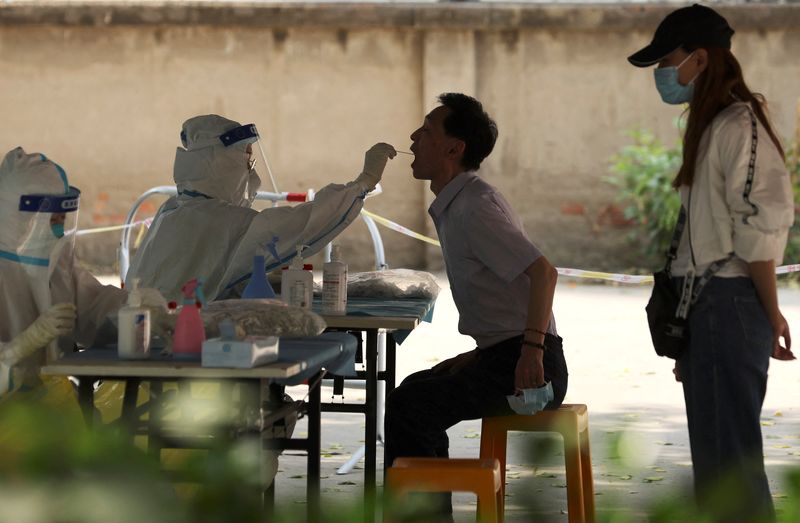 &copy; Reuters. A medical worker takes a swab sample from a person for a nucleic acid test at a makeshift testing site, amid the coronavirus disease (COVID-19) outbreak, in Beijing, China May 23, 2022. REUTERS/Tingshu Wang