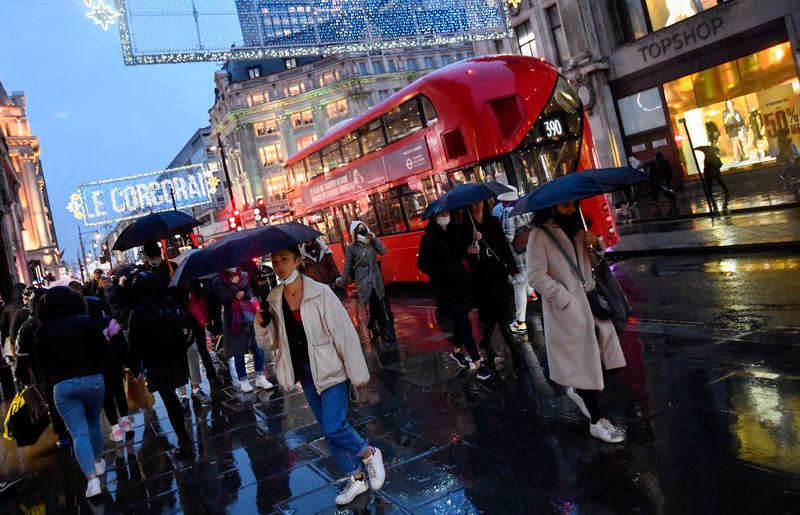 &copy; Reuters. FILE PHOTO: Shoppers hold umbrellas as they walk, following the outbreak of the coronavirus disease (COVID-19), at Oxford Street in London, Britain December 16, 2020. REUTERS/Toby Melville