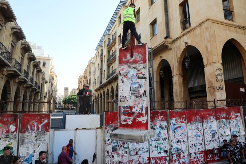 &copy; Reuters. أفراد يزيلون حائطا يسد أحد الشوارع المفضية إلى مقر البرلمان في بيروت يوم الاثنين. تصوير: محمد عزاقير - رويترز. 