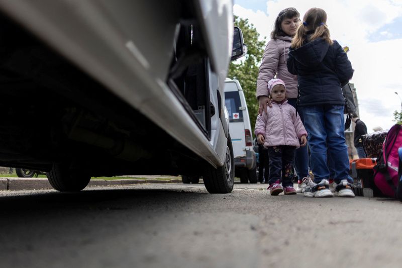 &copy; Reuters. امرأتان وطفلة ينتظرون حافلة للرحيل من سلوفيانسك باقليم دونيتسك الأوكراني يوم الاثنين. تصوير: كارلوس باريا - رويترز. 
