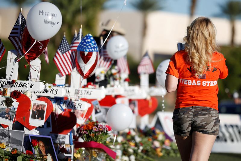&copy; Reuters. FILE PHOTO: A woman looks at white crosses set up for the victims of the Route 91 Harvest music festival mass shooting in Las Vegas, Nevada, U.S., October 7, 2017. REUTERS/Chris Wattie/File Photo