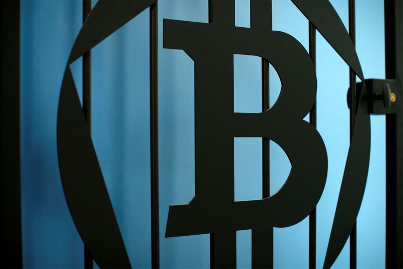 © Reuters. FILE PHOTO: The logo of bitcoin is pictured on a door in an illustration picture taken at La Maison du Bitcoin in Paris July 11, 2014.    REUTERS/Benoit Tessier/File Photo