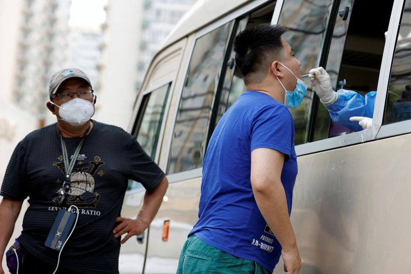 &copy; Reuters. Un trabajador médico con un traje de protección recoge un hisopo de un residente para las pruebas de ácido nucleico en un vehículo de pruebas móviles, en medio del brote de la enfermedad del coronavirus (COVID-19) en Pekín, China 24 de mayo de 2022.