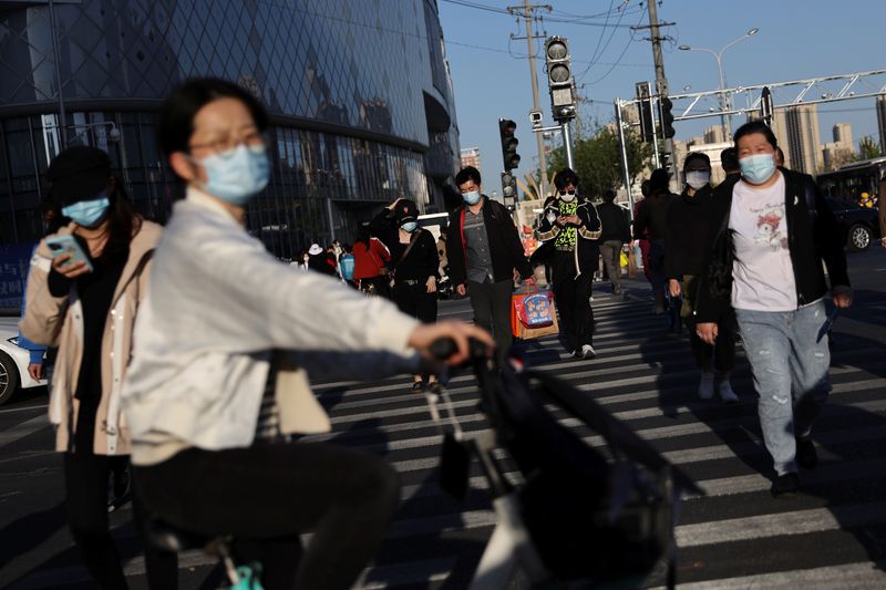 &copy; Reuters. Foto de archivo de per gente usando mascarillas en Pekín
