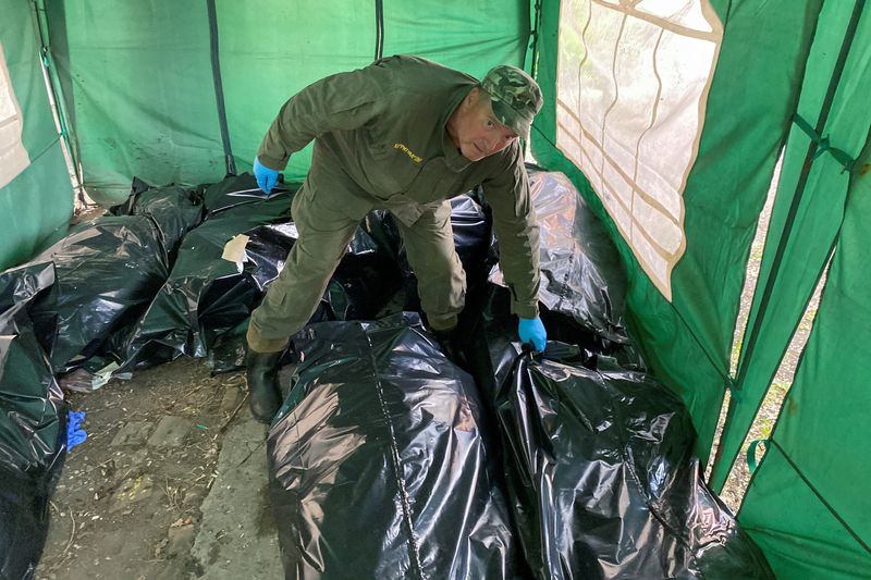 &copy; Reuters. Un operario apila cadáveres de soldados rusos antes de cargarlos en un ferrocarril refrigerado en una morgue de Járkov, Ucrania. 22 mayo 2022. REUTERS/Vitalii Hnidyi