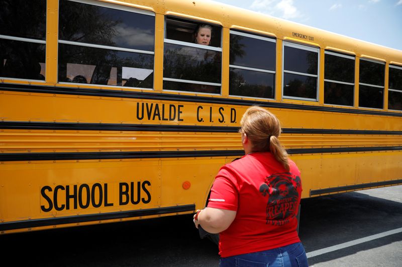 © Reuters. A school employee talks through the window of a school bus to one of the parents near the scene of a suspected shooting near Robb Elementary School in Uvalde, Texas, U.S. May 24, 2022.  REUTERS/Marco Bello