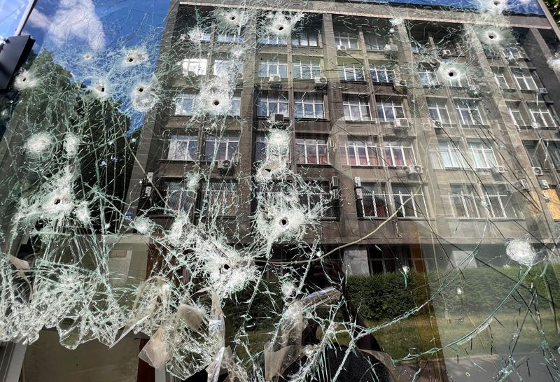 © Reuters. A building is reflected in a shop window at a residential area after a shelling with cluster ammunition, as Russia's attack on Ukraine continues, in Kharkiv, Ukraine May 23, 2022. REUTERS/Ivan Alvarado