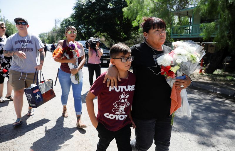 &copy; Reuters. Dora Flores et son petit-fils arrivent à l'école primaire Robb avec des fleurs, le lendemain de la fusillade à l'école d'Uvalde, au Texas (États-Unis). Le jeune homme ayant abattu mardi 19 enfants et deux enseignants avait écrit une quinzaine de min