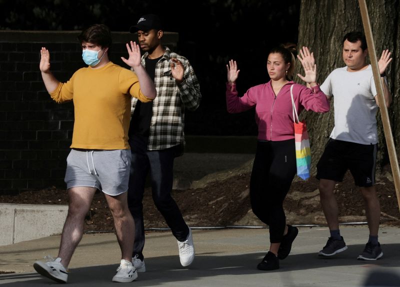 &copy; Reuters. FILE PHOTO: Local residents hold their hands in the air as they are evacuated to safety by police at the scene of a reported shooting and active shooter near Edmund Burke Middle School in the Cleveland Park neighborhood of Northwest Washington, U.S., Apri