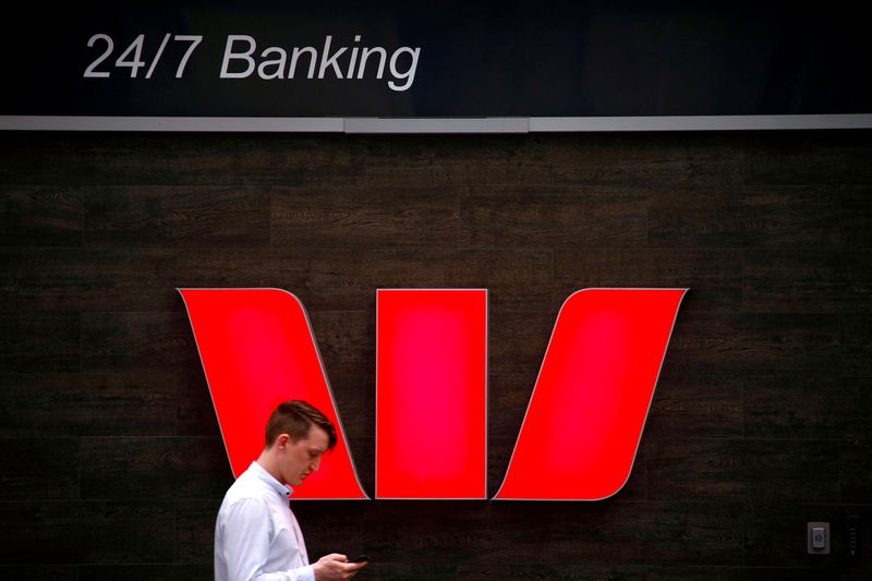 &copy; Reuters. FILE PHOTO: A pedestrian looks at his phone as he walks past a logo for Australia's Westpac Banking Corp located outside a branch in central Sydney, Australia, November 5, 2018.   REUTERS/David Gray