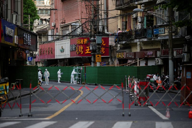 &copy; Reuters. عمال يرتدون ملابس واقية من الإصابة بفيروس كورونا في منطقة سكنية مغلقة في شتغهاي بالصين يوم الأربعاء. تصوير: ألي سونغ - رويترز.