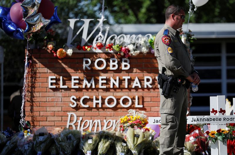 &copy; Reuters. A Texas Department of Public Safety officer stands in front of crosses with the names of victims of a school shooting, at a memorial outside Robb Elementary school, two days after a gunman killed nineteen children and two adults, in Uvalde, Texas, U.S. Ma