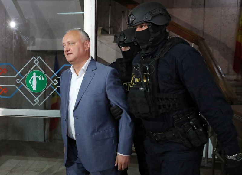 &copy; Reuters. Moldova's former President Igor Dodon, detained on corruption charges, is escorted by law enforcement officers before a court hearing in Chisinau, Moldova May 26, 2022. REUTERS/Vladislav Culiomza