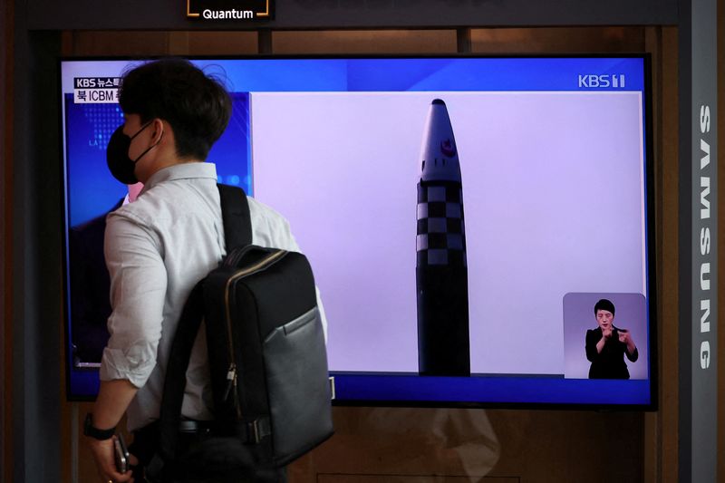 &copy; Reuters. IMAGEN DE ARCHIVO. Un hombre pasa frente a un televisor que transmite un informe de noticias sobre el lanzamiento de tres misiles por parte de Corea del Norte, incluido uno que se cree que es un misil balístico intercontinental (ICBM), en Seúl, Corea de
